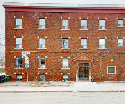 A red brick building with a yellow sign on the right side.