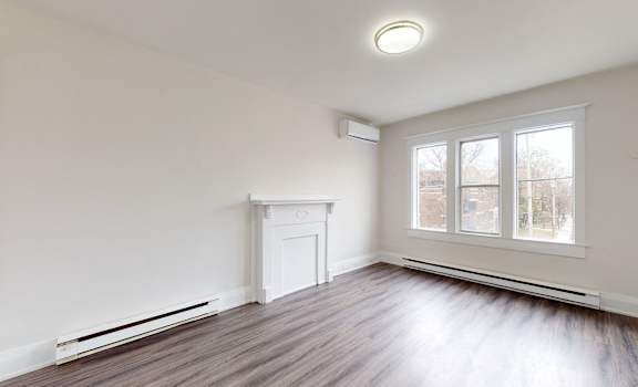 A room with a fireplace and a window.