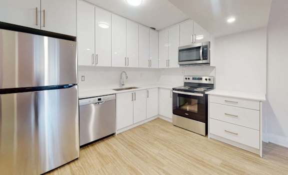 A modern kitchen with stainless steel appliances and white cabinets.