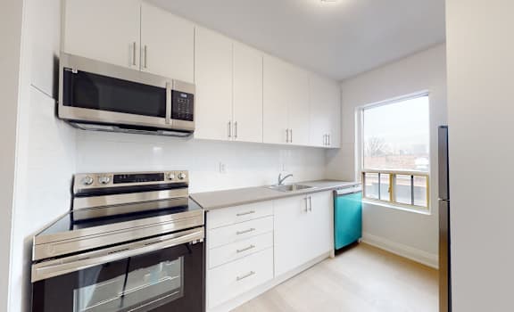 A kitchen with white cabinets and a black stove top oven.