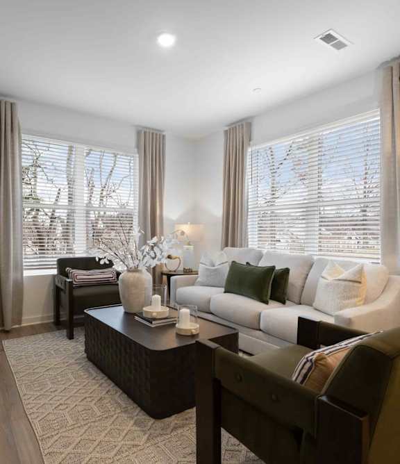 A modern living room with a dark brown sofa, a wooden coffee table, and a flat-screen TV mounted on the wall.