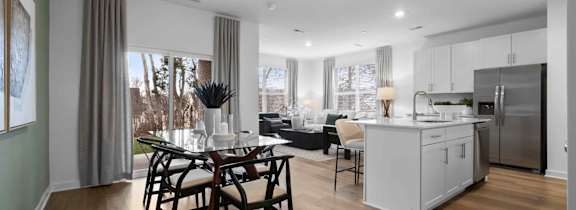 A modern kitchen with a dining table and chairs.