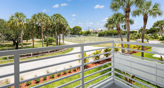 the view from the balcony of a condo with palm trees
