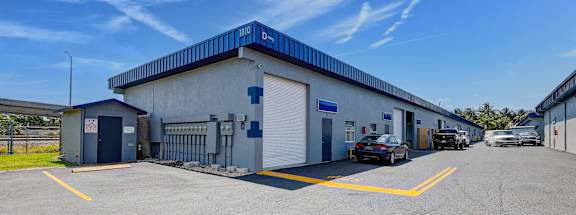 A blue warehouse with cars out front