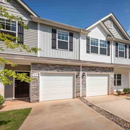 A row of houses with garages and driveways.