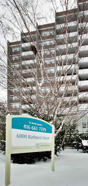 a sign in front of an apartment building in the snow