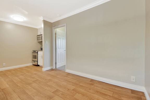 A room with wooden floors and a window with blinds.