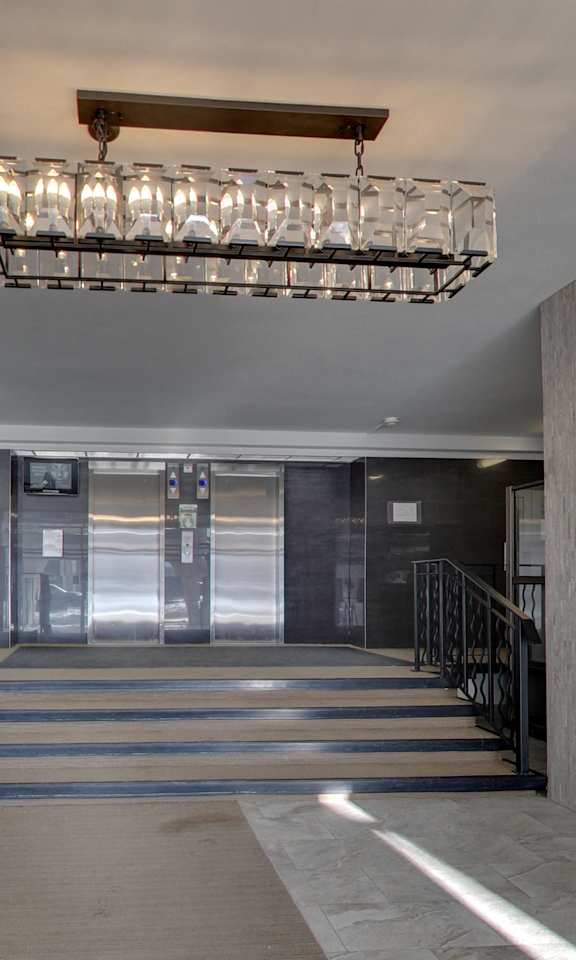 a lobby with a staircase and a large chandelier