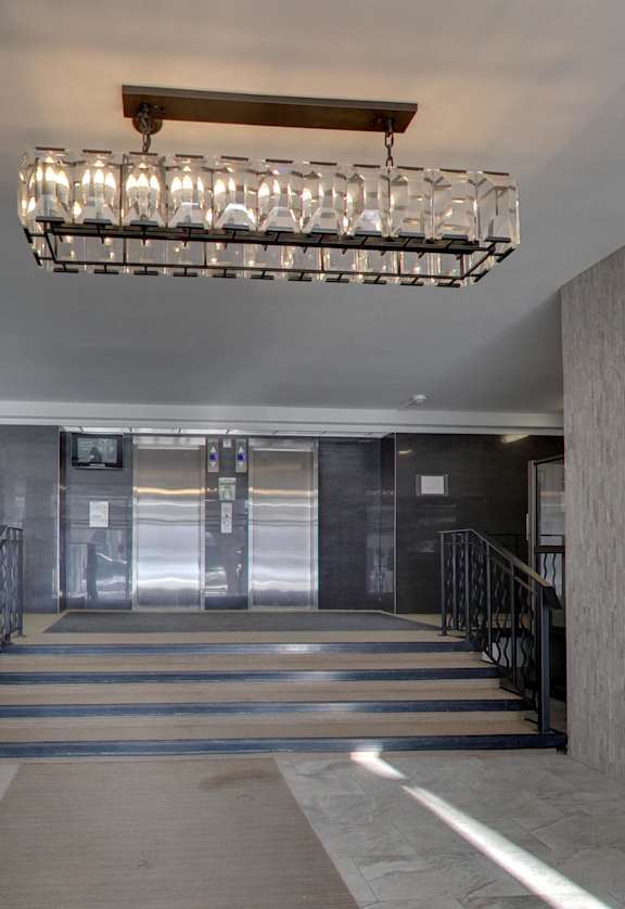 a lobby with a staircase and a large chandelier