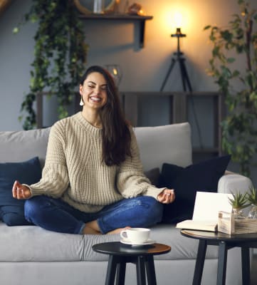 Lifestyle image of woman smiling on the couch