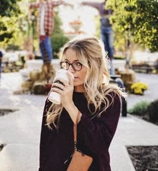 a woman is drinking from a coffee cup