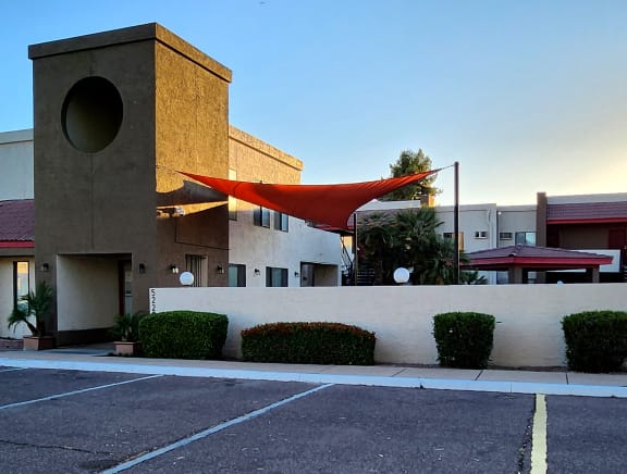 a building with a red awning in front of a parking lot