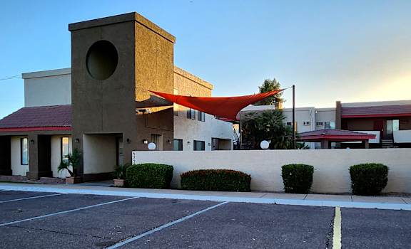 a building with a red awning in front of a parking lot