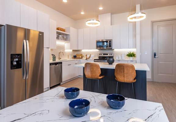 a kitchen with stainless steel appliances and a marble counter top at Zeta Luxury Apartments in Sacramento, CA