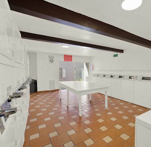 A laundry room with a washer and dryer on the right and a white table in the middle.