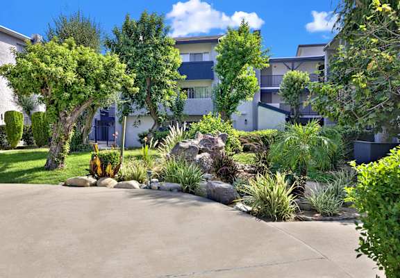 A residential area with a well-maintained garden and apartment buildings.