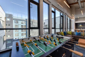 Community Clubhouse Foosball Table with View of Outside Apartment Exteriors through Large Window