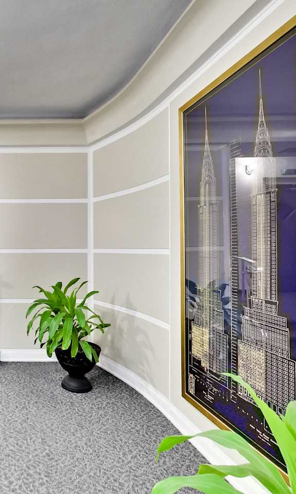 a lobby of a hotel with a plant and a staircase