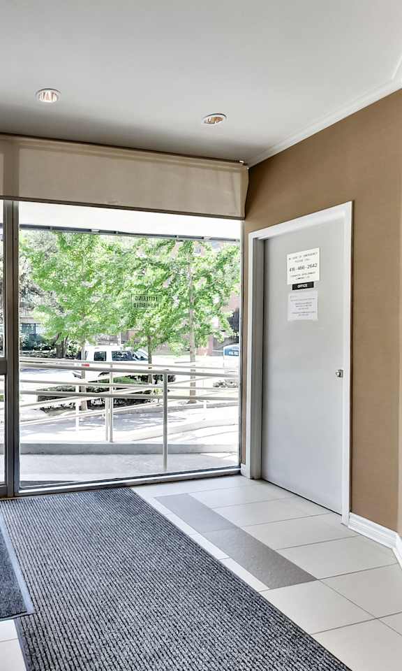 a lobby with glass doors and a view of a parking lot