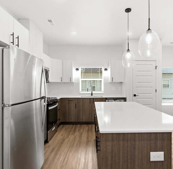A modern kitchen with a large island and stainless steel appliances.