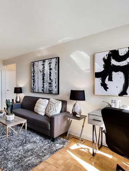 A living room with a couch, a chair, a coffee table, and a TV.