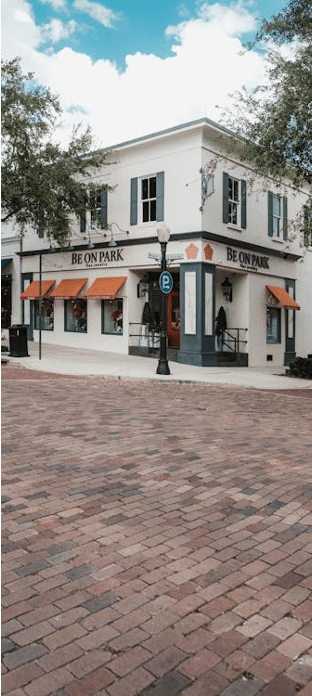A white building with a red awning and the words "Be On Park" written on it.