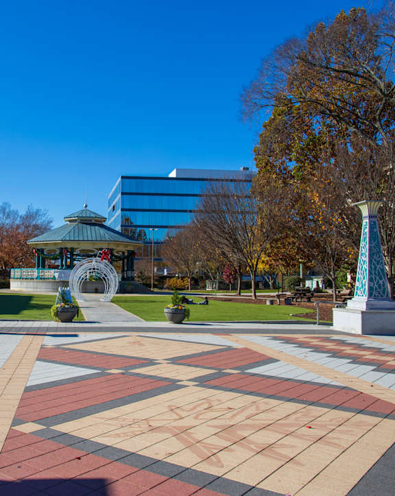 A park with a large plaza and a statue in the middle.