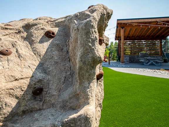 a rock with holes in it and a building in the background