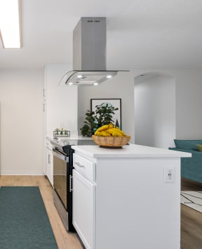 a kitchen with white cabinets and stainless steel appliances and a counter top with a basket