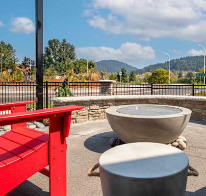 an outdoor patio with red benches and tables and a fountain