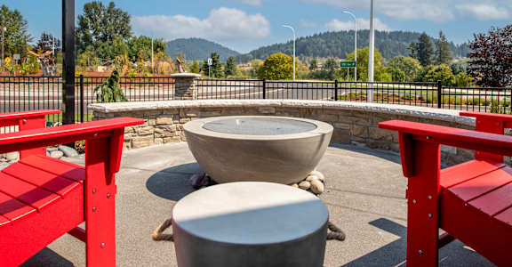 an outdoor patio with red benches and tables and a fountain at Scouter's Mountain, Oregon, 97086