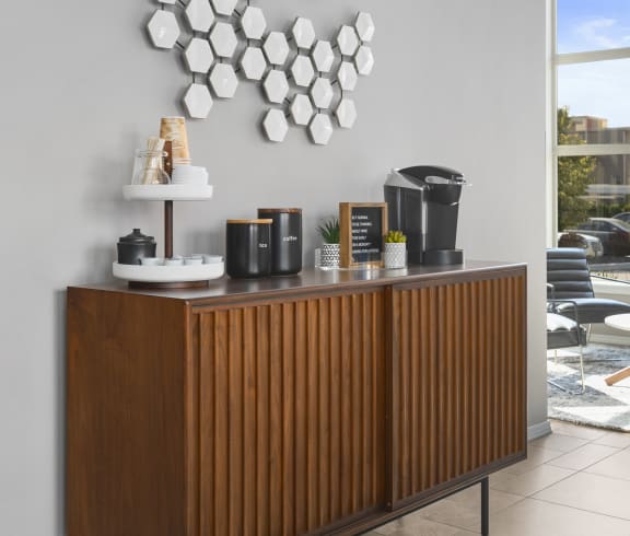 a coffee counter with coffee pots and a plate rack on top of it