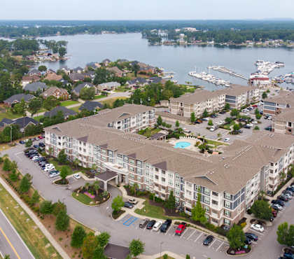 an aerial view of a large apartment complex with a marina in the background
