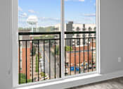Thumbnail 3 of 9 - A white window with a black railing overlooking a street.