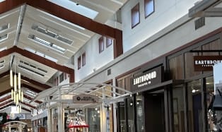 a store front of a shopping mall with a red trolley