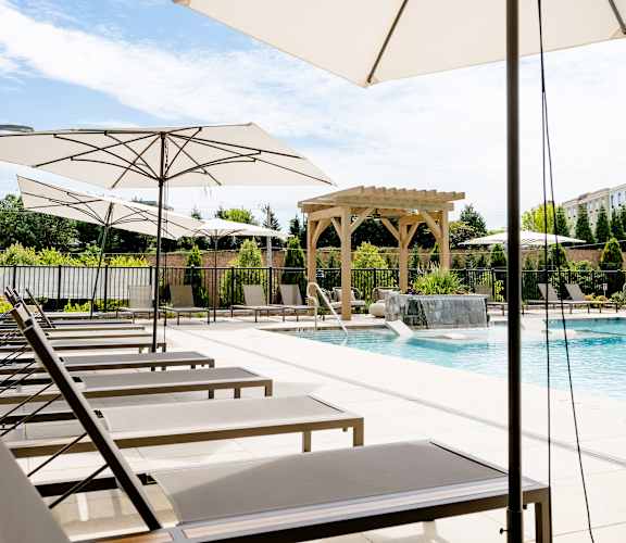 a pool with lounge chairs and umbrellas