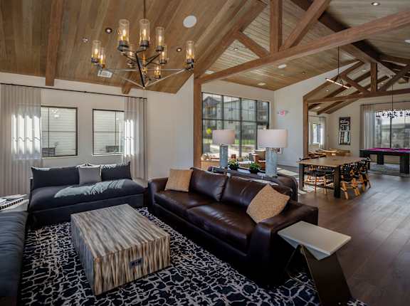 A modern living room with a dark brown leather couch and a wooden coffee table.