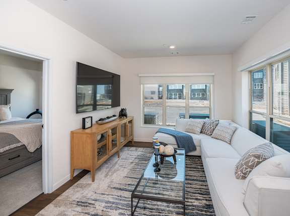 a living room with a white couch and a television