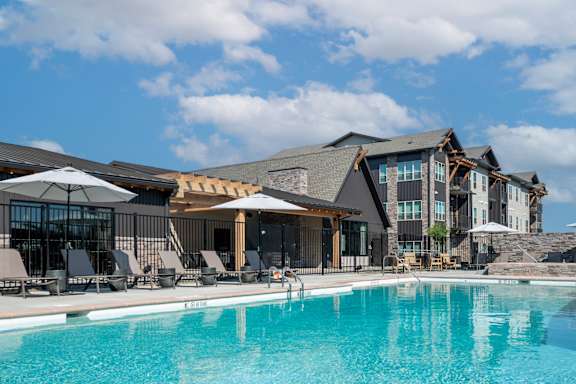 A large swimming pool in front of a resort.