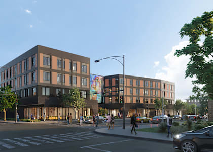 A street view of a modern building with people walking on the sidewalk.