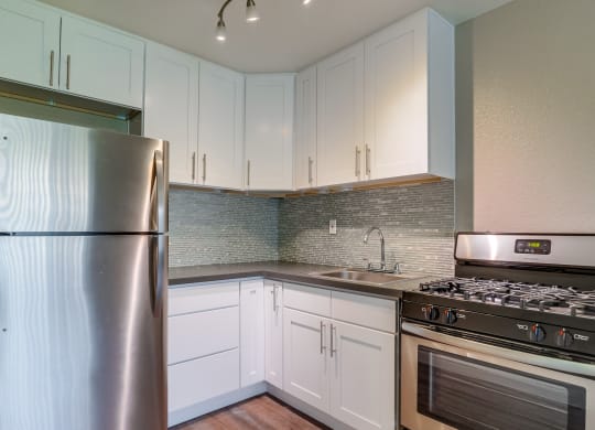 Kitchen with stainless steel appliances, and modern wood cabinets at Las Brisas Apartments, Colton, CA, 92324
