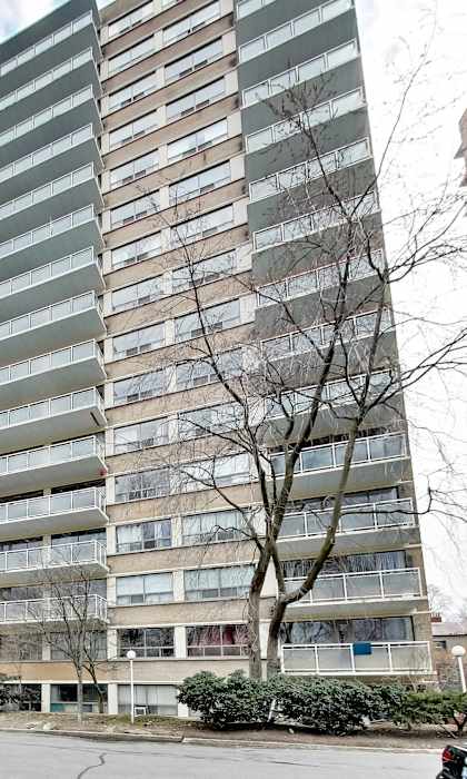 A tall residential building with a pool in front.