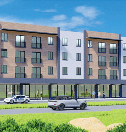 A row of modern apartment buildings with cars parked in front.
