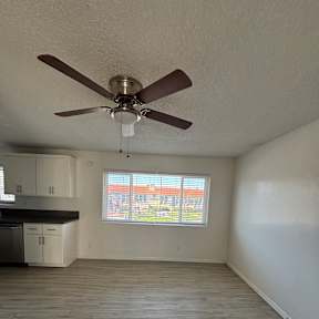 A room with a ceiling fan and a window.