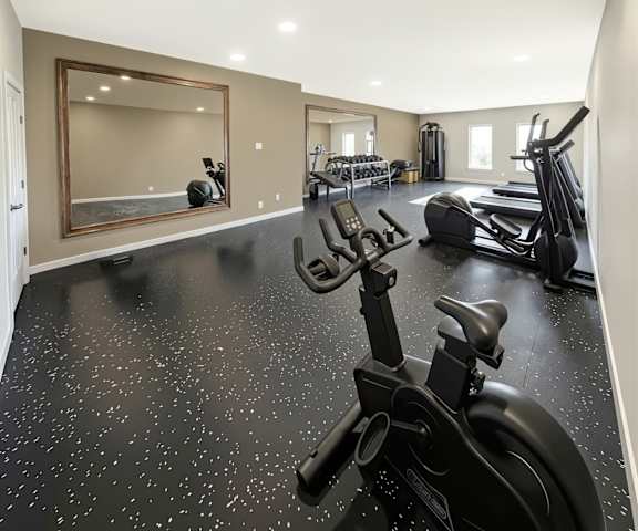 A black and white speckled floor in a gym with a mirror and exercise equipment.