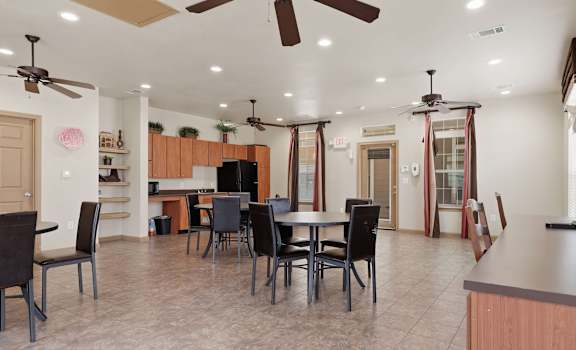 A kitchen with a dining table and chairs.