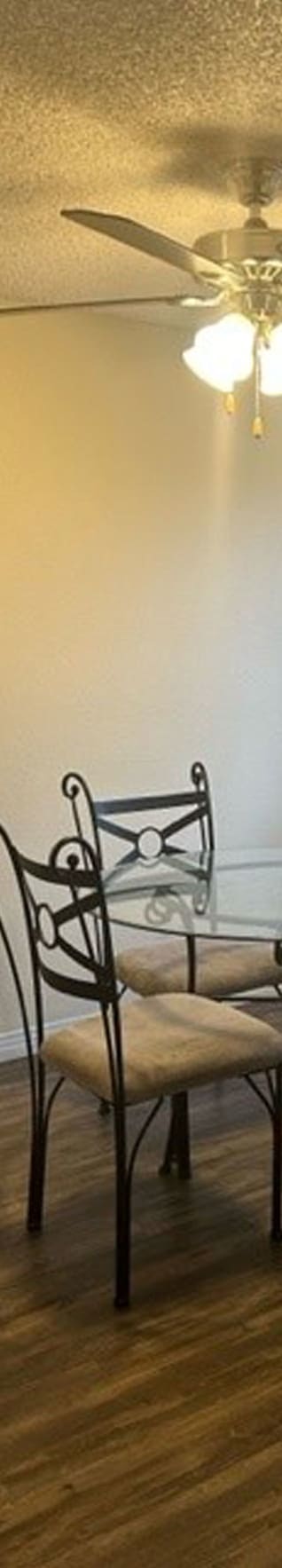 a room with a table and chairs and a ceiling fan