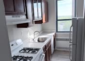 Thumbnail 5 of 40 - A kitchen with white appliances and brown countertops.
