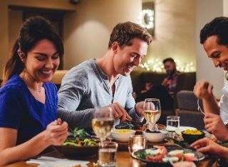 A group of people enjoying a meal together at a table.