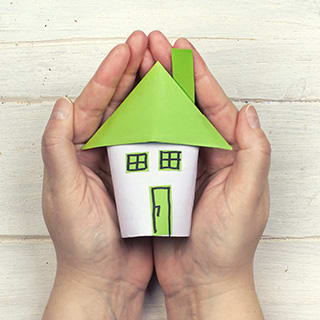 a pair of hands holding a small house at The Terminal Tower Residences Apartments, Ohio, 44113